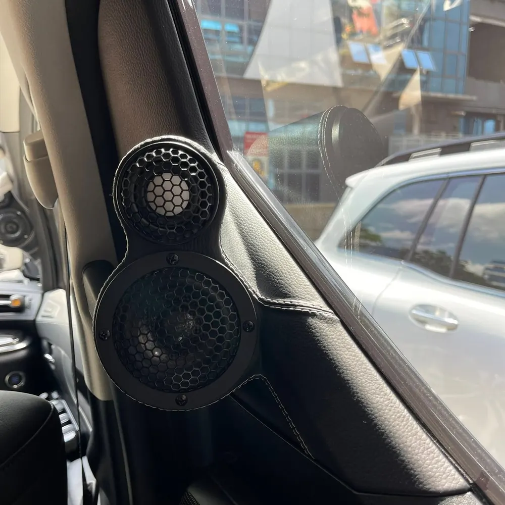 Close-up of custom A-pillar speaker pods with contrast stitching